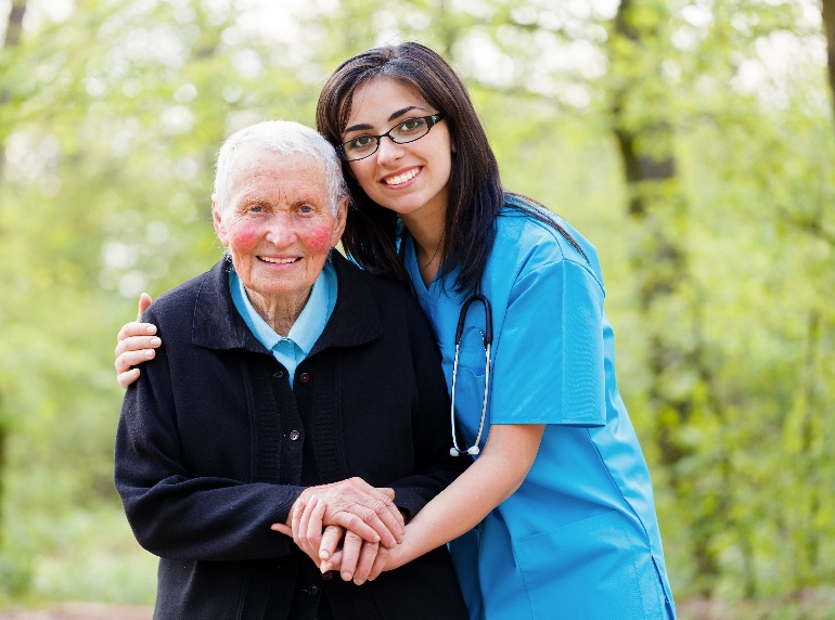 A Holy Home caregiver embracing a senior client outdoors
